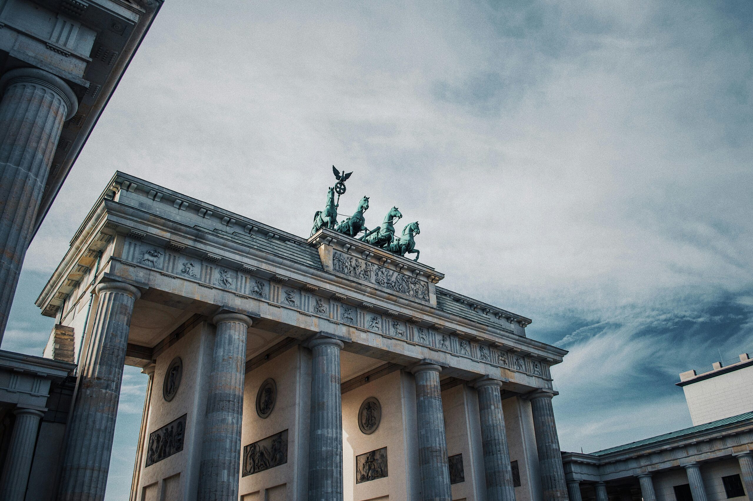 Iconic Brandenburg Gate in Berlin showcasing historical architecture against a dramatic sky.
